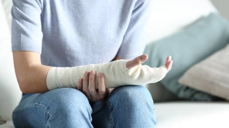 Disabled woman grabbing her painful bandaged arm